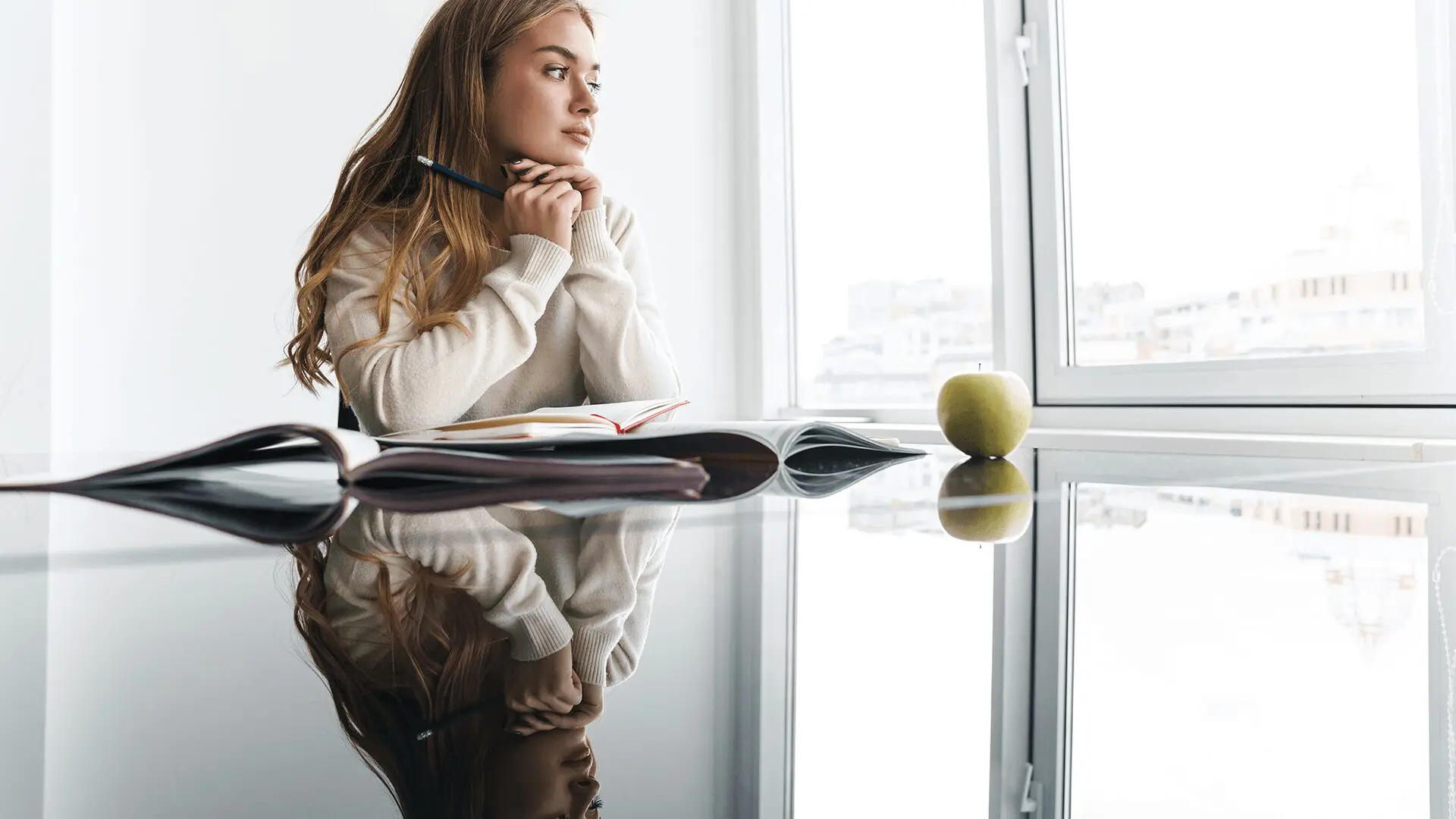 Businesswoman holding pen and looking at the window